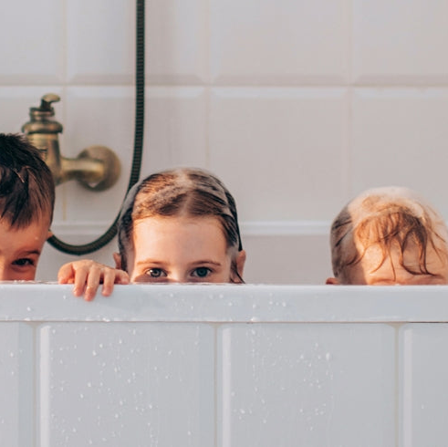 Kinder, die aus einer Badewanne schauen