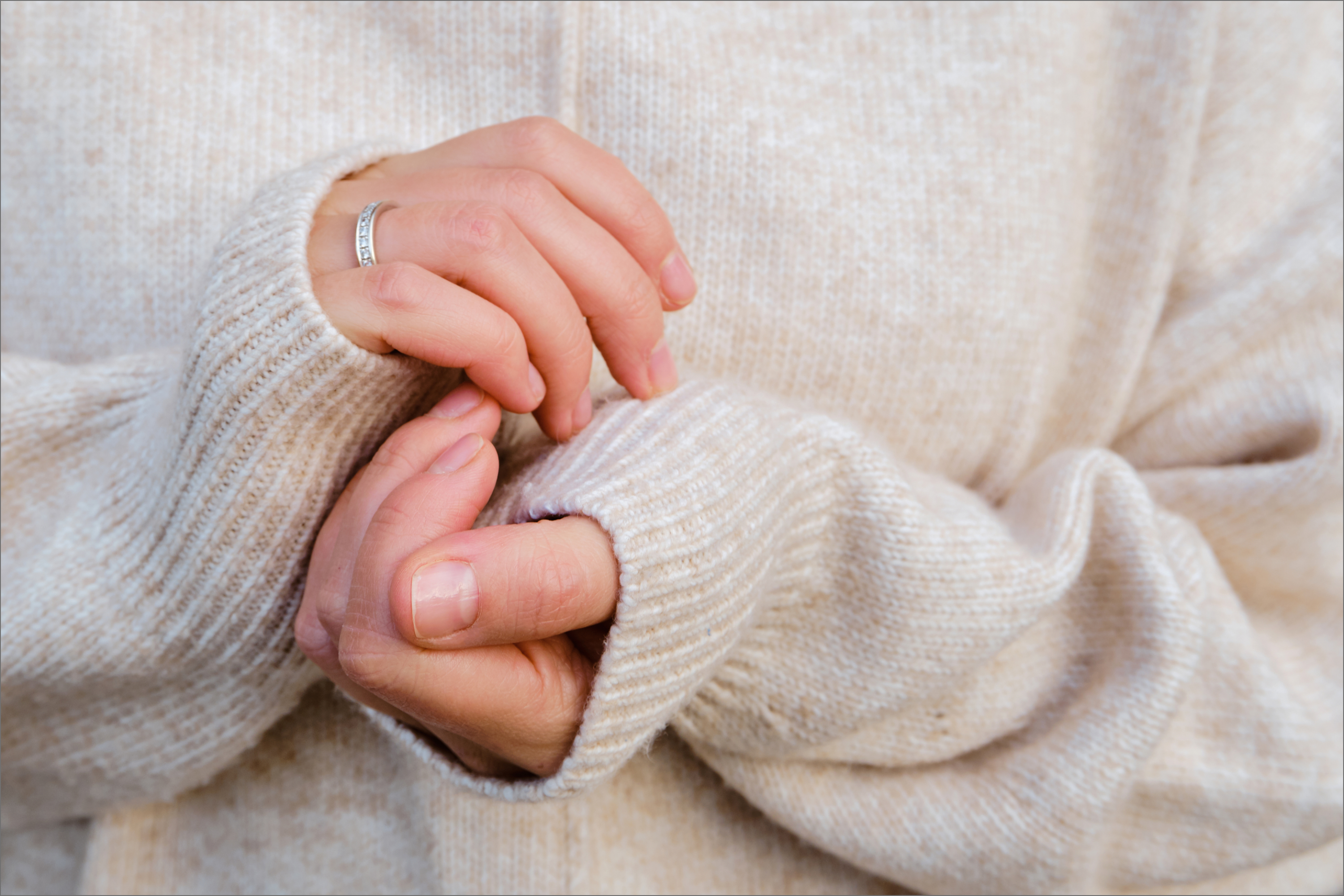 Hände und Oberkörper im kuscheligen Wollpullover
