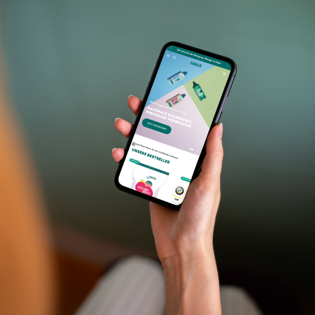 Smartphone in einer Hand, dass haka.com zeigt