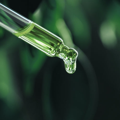 Aus einer Pipette tropft grüne Flüssigkeit