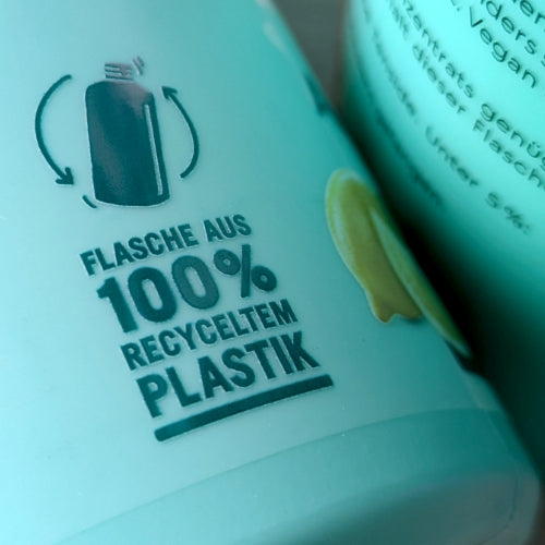 Zoom auf eine Allesreinigerflasche mit den Worten "Flasche aus 100% recyceltem Plastik".