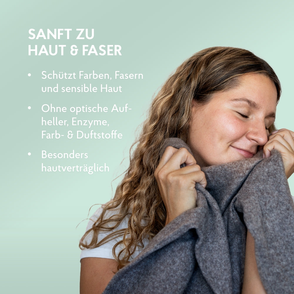 Frau hält kuscheligen Pullover an ihre Wange