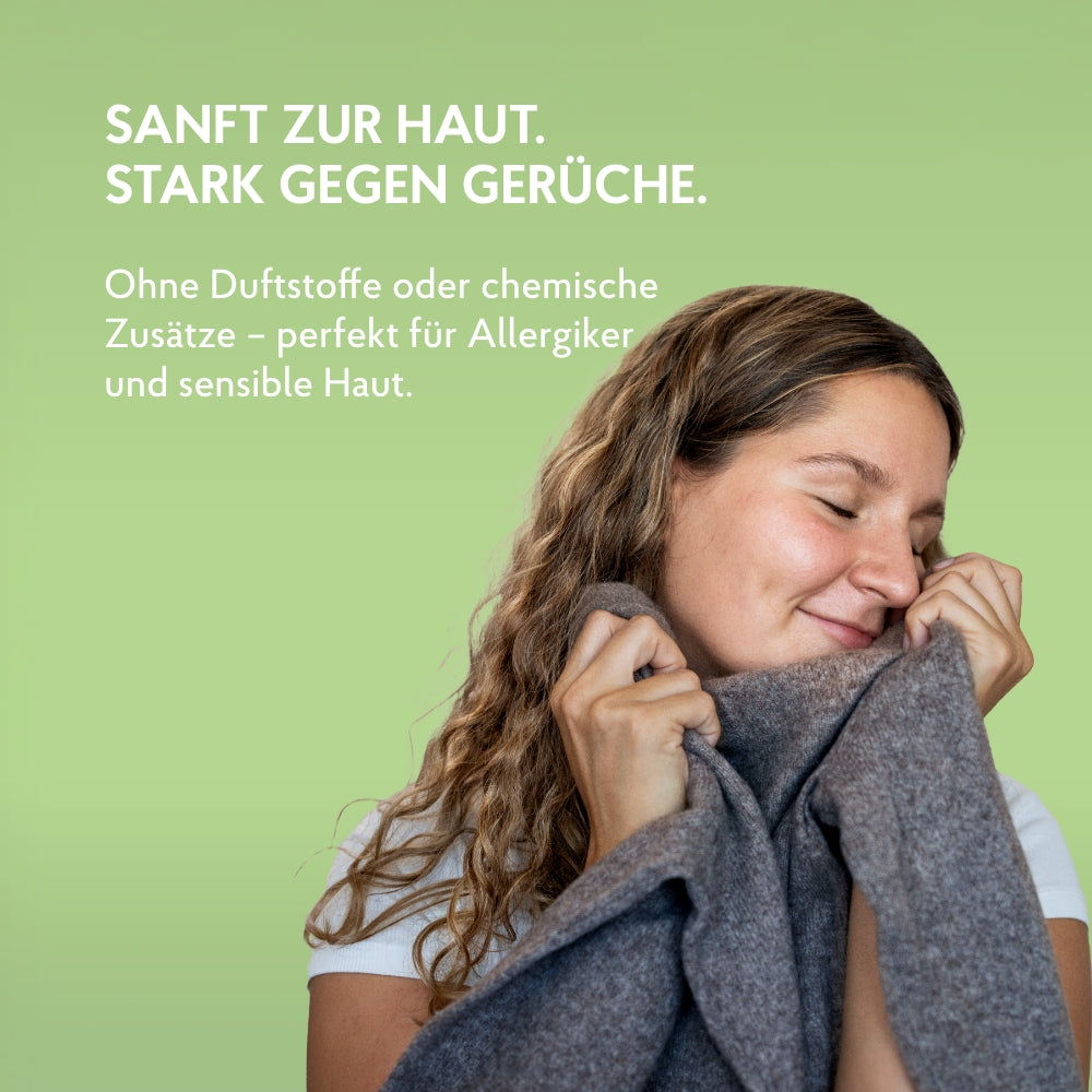 Junge Frau riecht an frisch gewaschenem Pullover