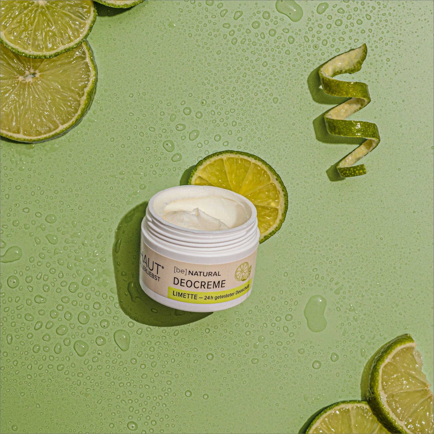 Deocreme Limette auf einem Hintergrund mit Wassertropfen und Limettenscheiben
