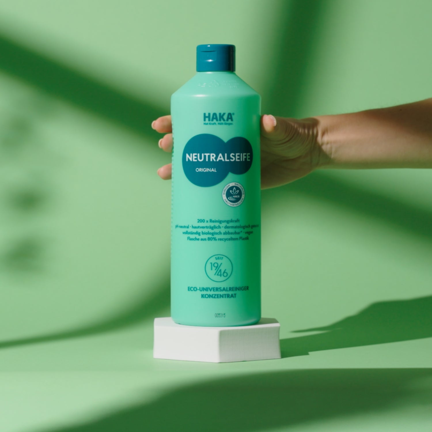 Neutralseife Original auf einem Steinsockel vor grünem Hintergrund