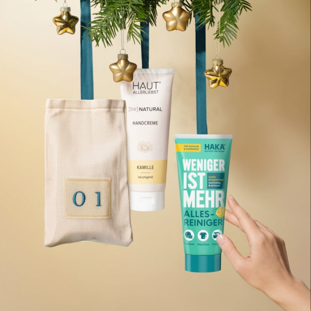 Adventskalendersäckchen und Produkte an Tannenzweigen. 