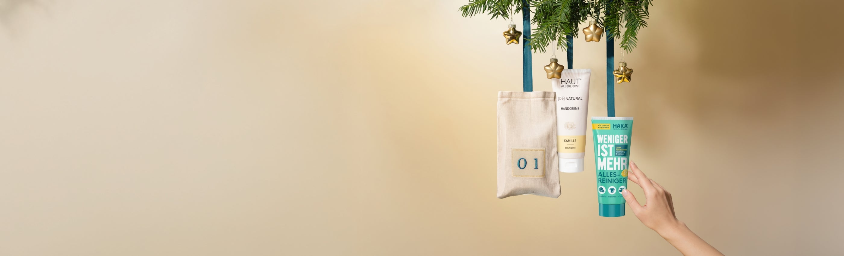 An Tannenweigend hängen ein Adventskalendersäckchen und HAKA Produkte